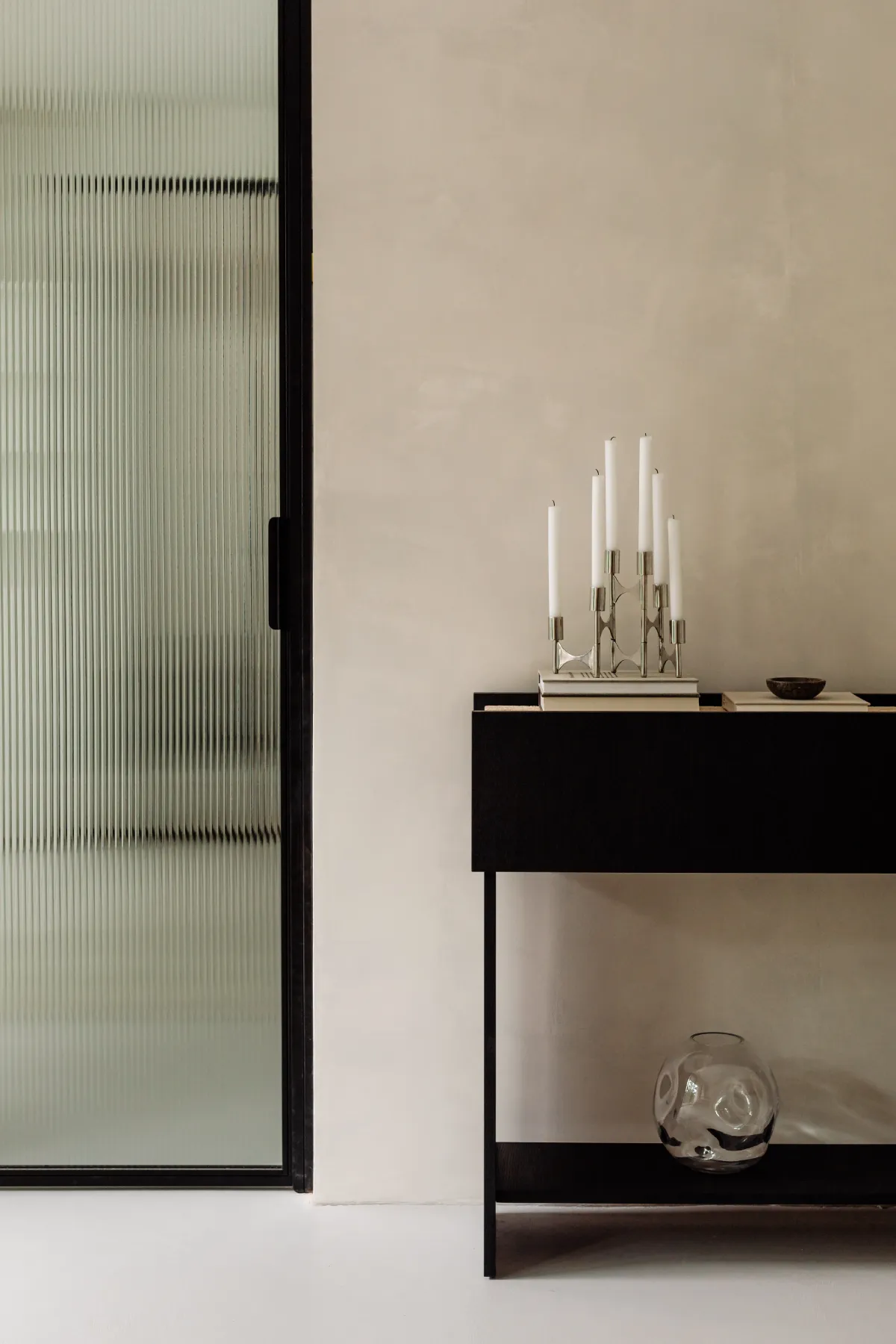 Décor intérieur avec un meuble noir et une porte vitrée Décor intérieur avec un meuble noir et une porte vitrée