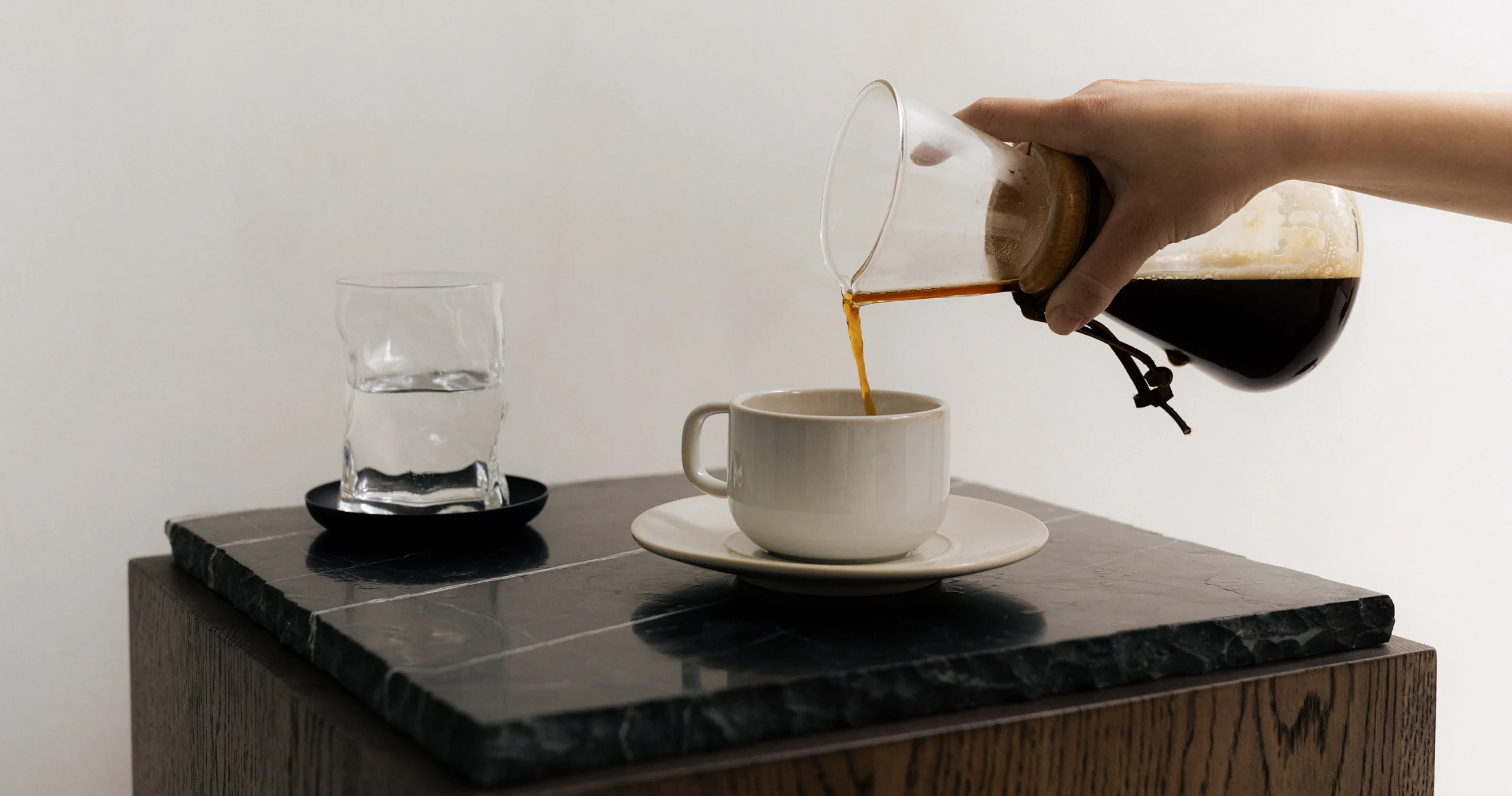 Café versé dans une tasse blanche sur une table en marbre noir