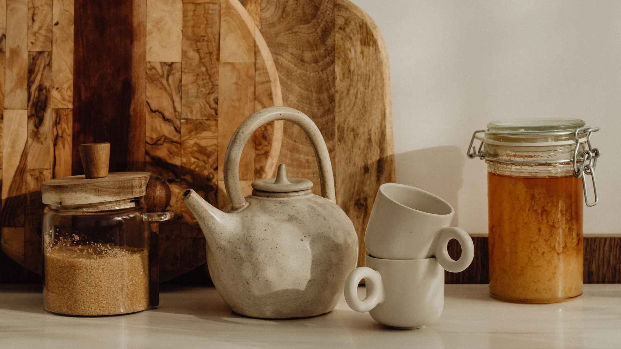 Comptoir de cuisine avec théière en céramique, planches en bois et bocaux