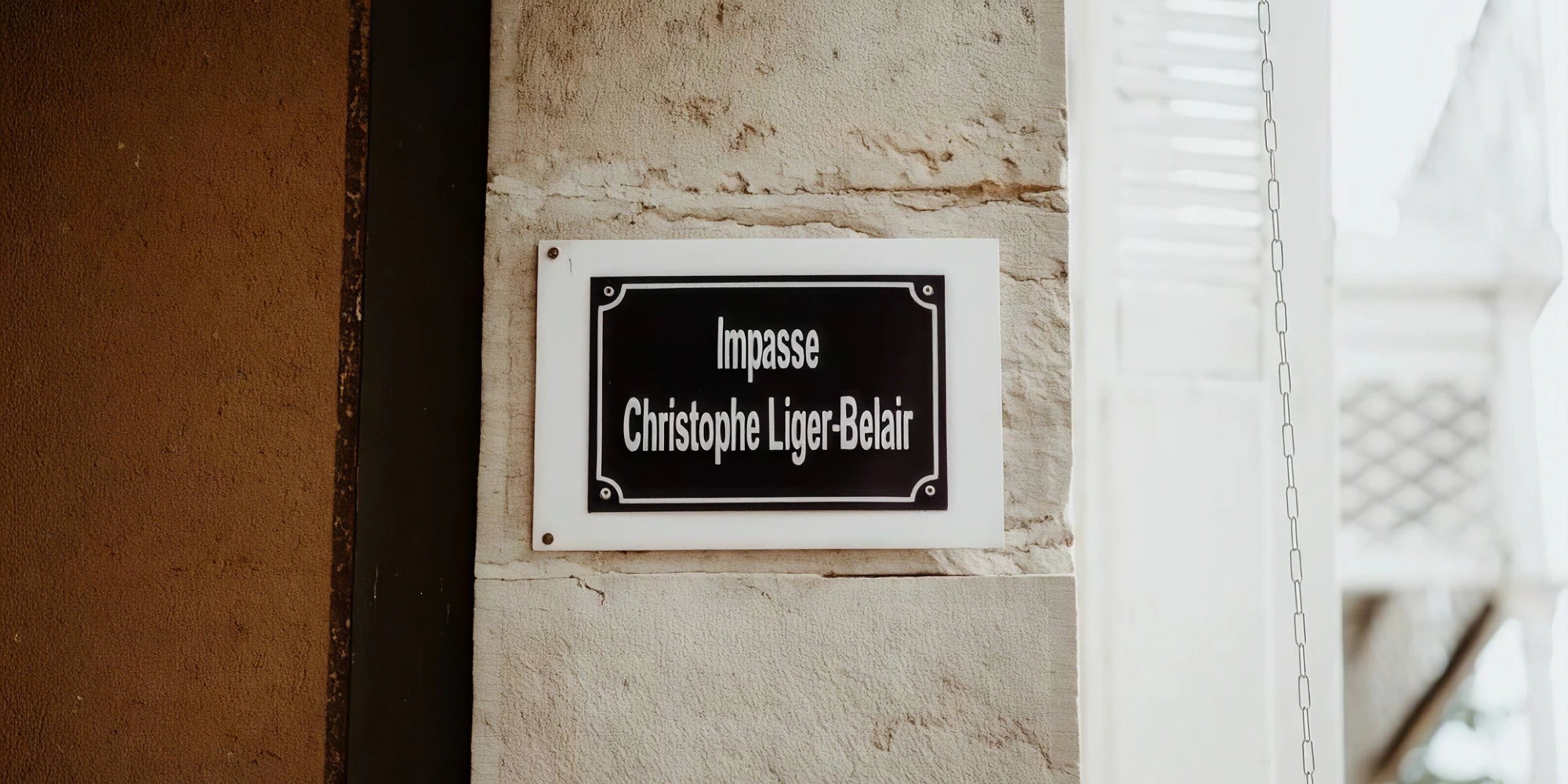 La plaque « Impasse Christophe Liger-Belair » sur un pilier en pierre du domaine des Maisons du Bonheur