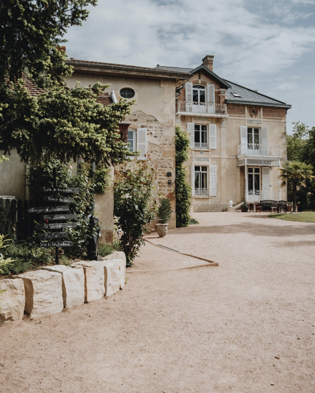 La façade du domaine des Maisons du Bonheur, au bout de l'allée de gravier