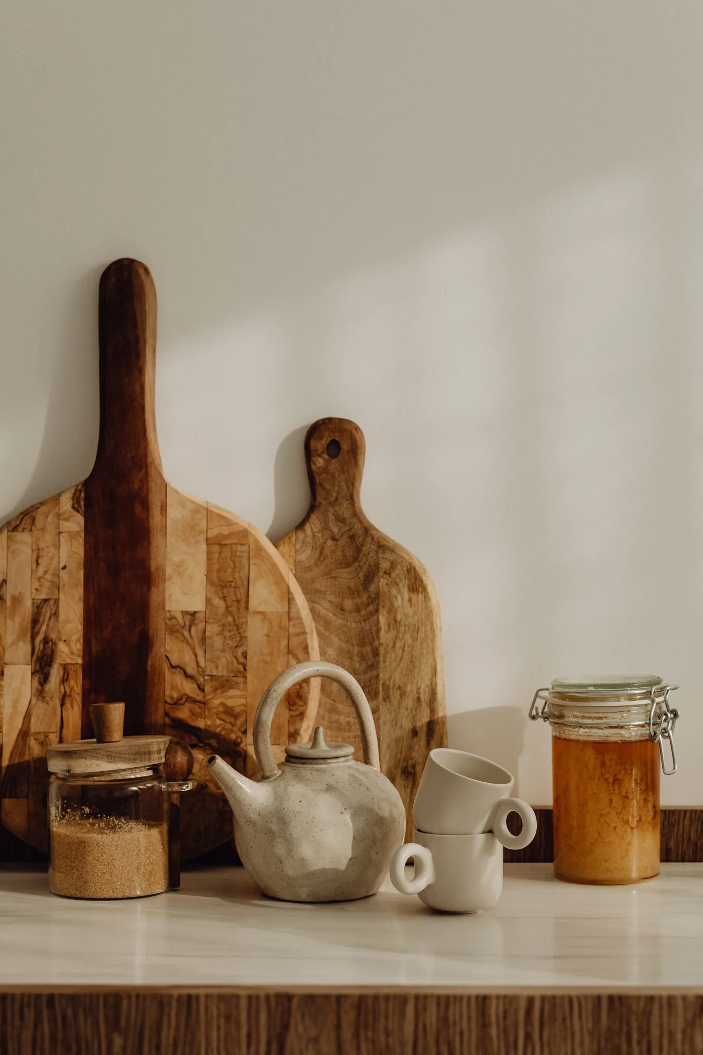 Comptoir de cuisine avec théière en céramique, planches en bois et bocaux